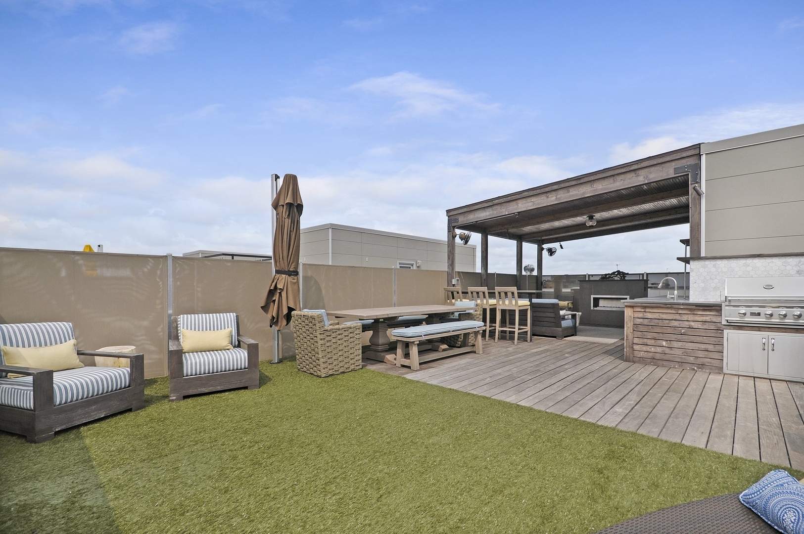 1124 West Adams Street, Unit PHW Chicago, IL 60607 - Photo 27 of 55 a roof deck with table and chairs couches with wooden floor and fence