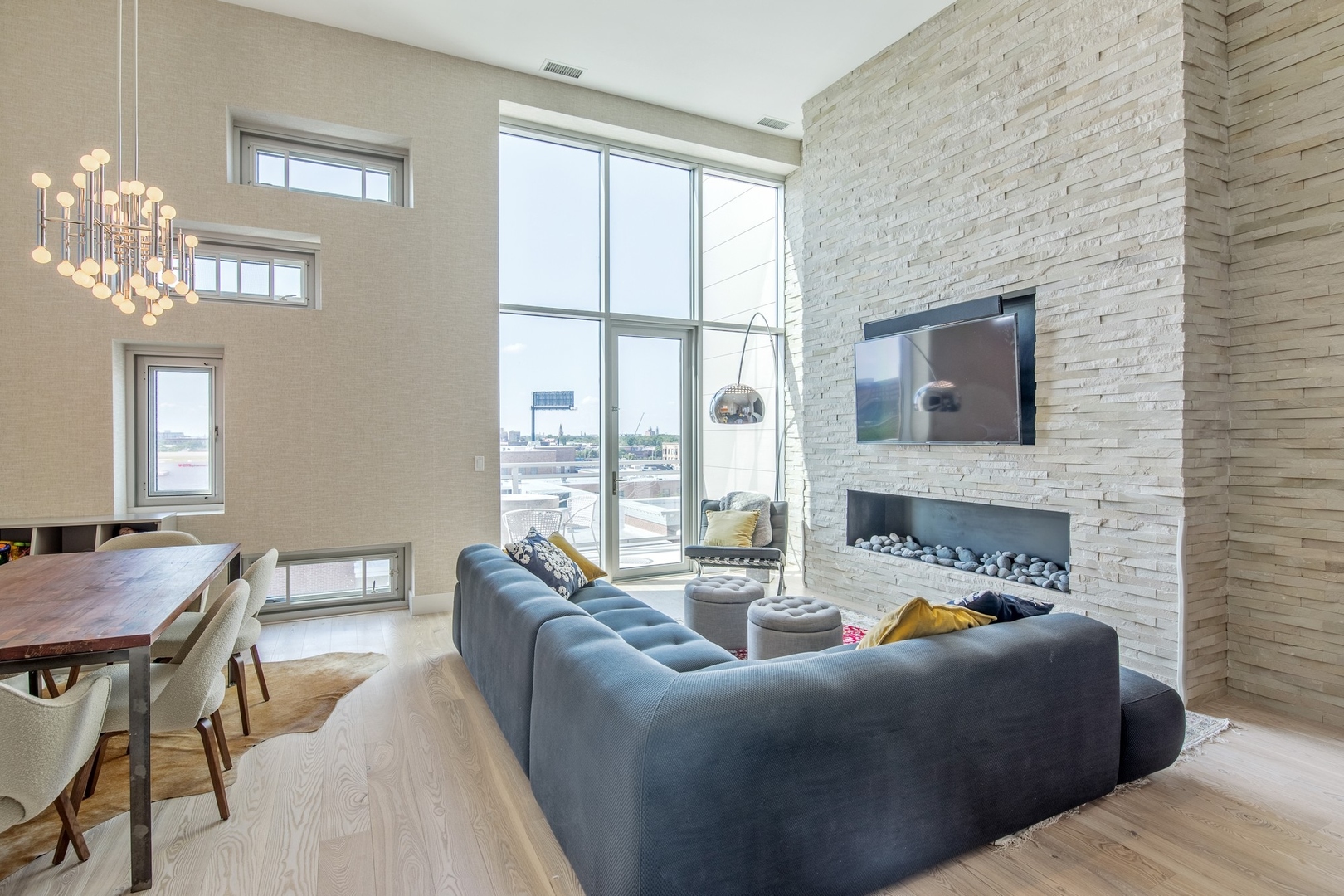 1124 West Adams Street, Unit PHW Chicago, IL 60607 - Photo 4 of 55 a living room with furniture a large window and a flat screen tv