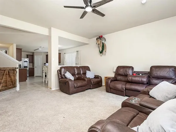 a living room with furniture and a ceiling fan