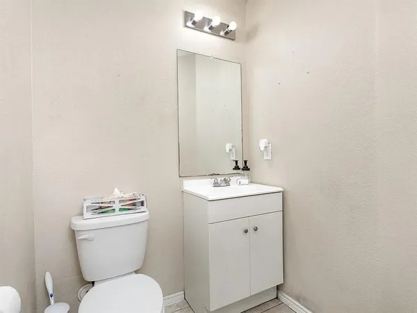 a bathroom with a toilet sink and mirror