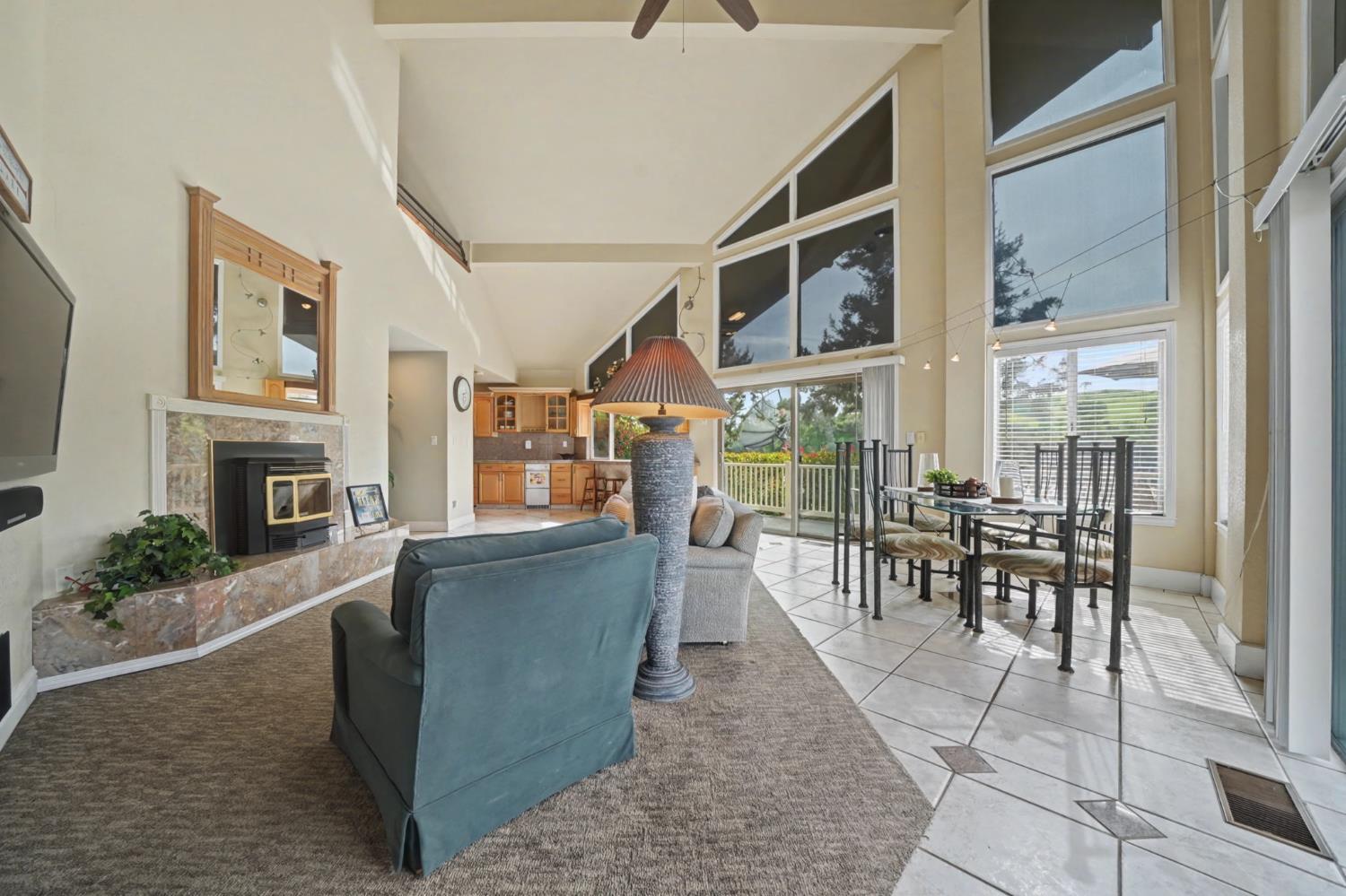450 Lakeview Road Copperopolis, CA 95228 - Photo 35 of 93 a living room with furniture a fireplace and a floor to ceiling window
