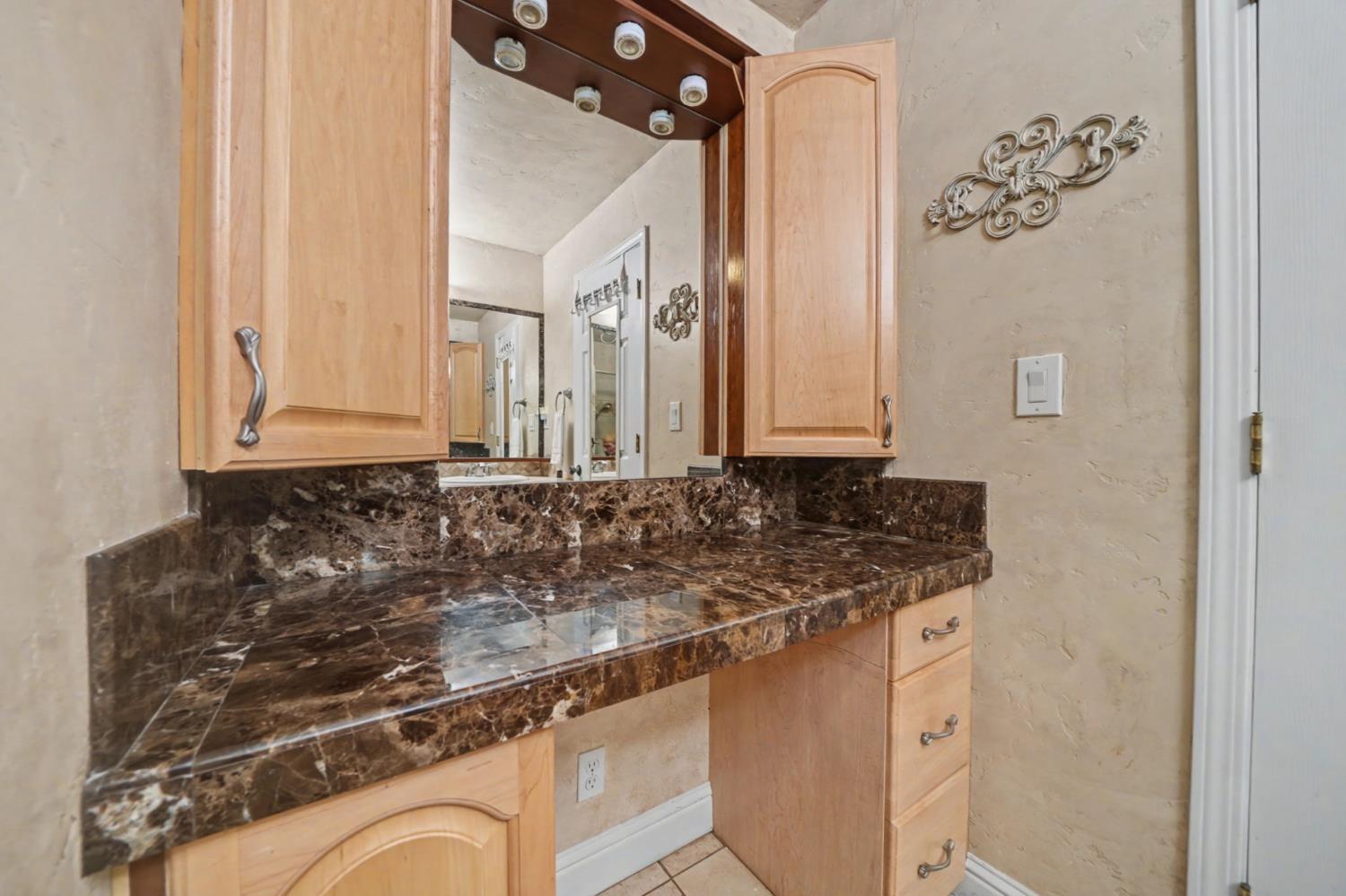450 Lakeview Road Copperopolis, CA 95228 - Photo 42 of 93 a bathroom with a granite countertop sink and a mirror