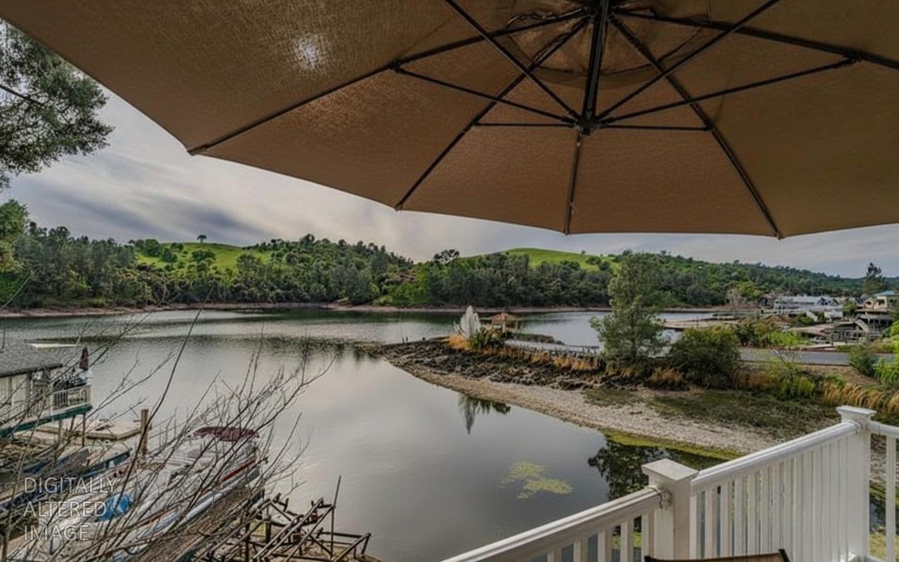 450 Lakeview Road Copperopolis, CA 95228 - Photo 93 of 93 a view of a lake with a table and chairs under an umbrella