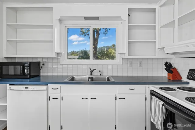 a kitchen with granite countertop a sink stainless steel appliances and cabinets