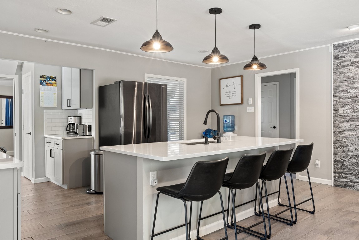 a kitchen with stainless steel appliances a dining table chairs and refrigerator