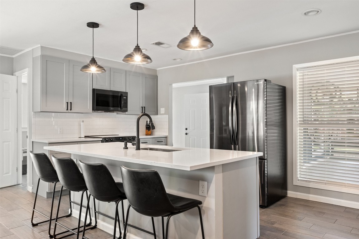35 Presidio Road Wimberley, TX 78676 - Photo 13 of 39 a kitchen with stainless steel appliances granite countertop a sink a stove a refrigerator with a dining table and chairs