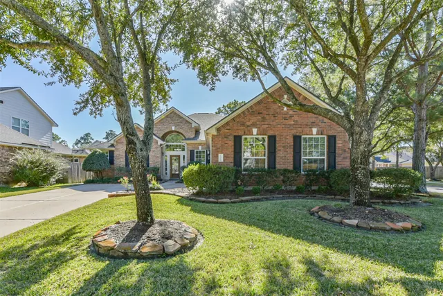 a front view of a house with a yard and tree