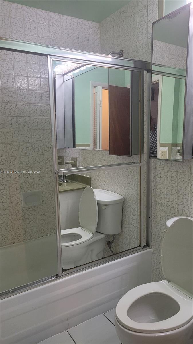1793 Southwest 5th Street, Unit 401 Miami, FL 33135 - Photo 8 of 12 a bathroom with a toilet a sink and mirror