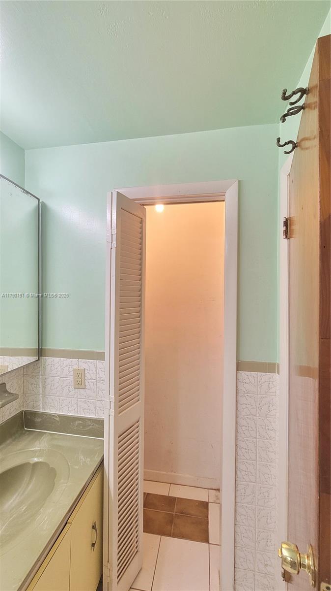 1793 Southwest 5th Street, Unit 401 Miami, FL 33135 - Photo 10 of 12 a bathroom with a granite countertop sink and a mirror