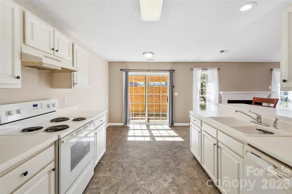 a large white kitchen with stainless steel appliances a stove a sink and white cabinets