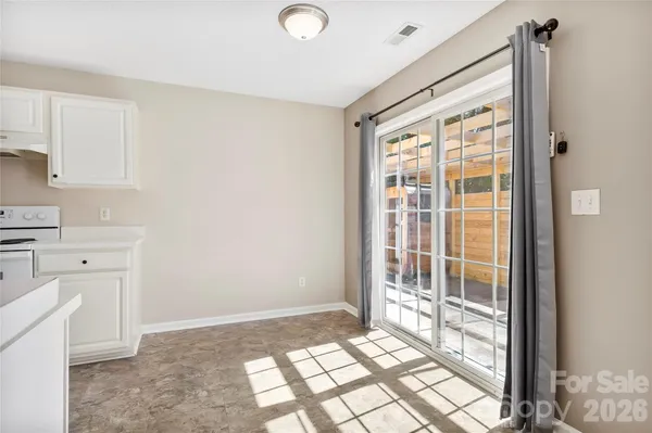 a view of a kitchen with white cabinets and wooden floor