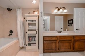 896 Davis Road League City, TX 77573 - Photo 35 of 46 a bathroom with a tub a double vanity sink and mirror