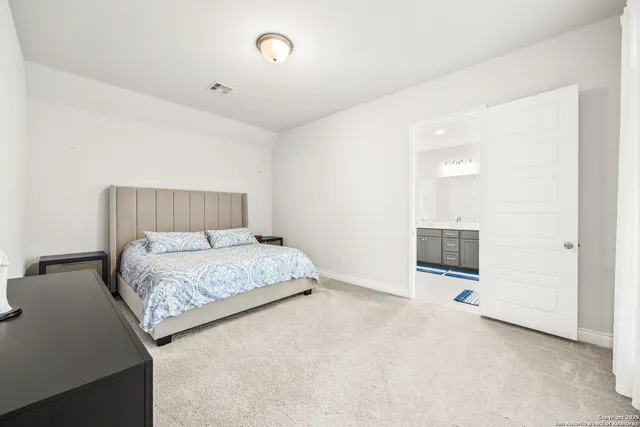 a bedroom with a bed and painting on the wall