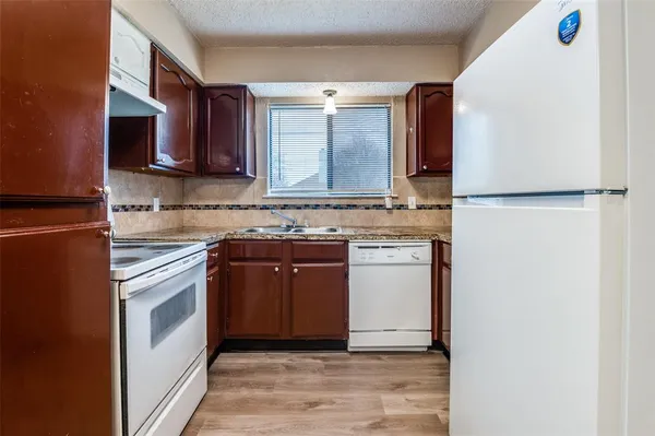 a kitchen with stainless steel appliances granite countertop a refrigerator a stove a sink and a microwave
