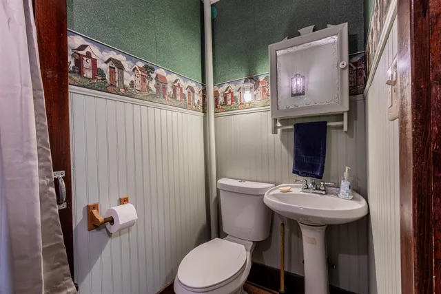 a bathroom with a sink a toilet and mirror