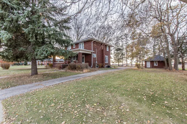 a brick house with trees in front of it
