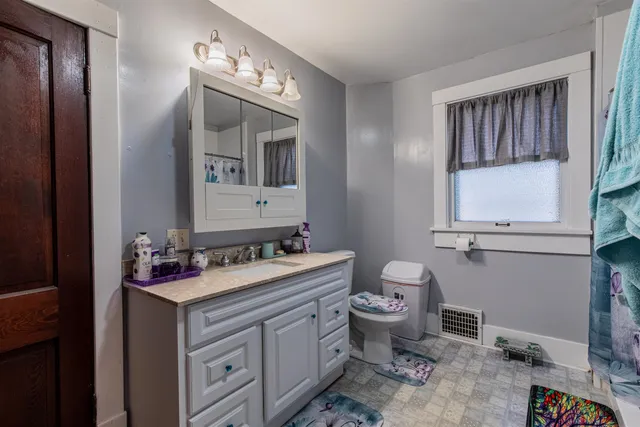 a bathroom with a toilet sink and mirror