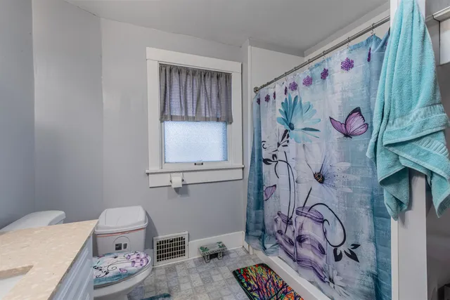a bathroom with a granite countertop sink and a toilet