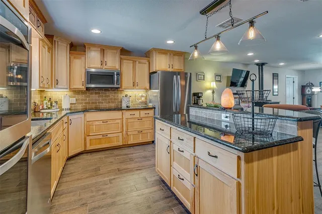 a spacious bathroom with a granite countertop sink a mirror and shower