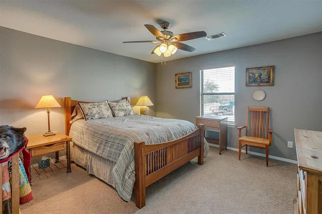 a spacious bedroom with a bed a couch and a chandelier