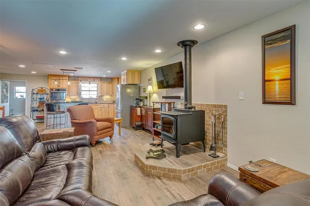 a living room with furniture kitchen view and a large window