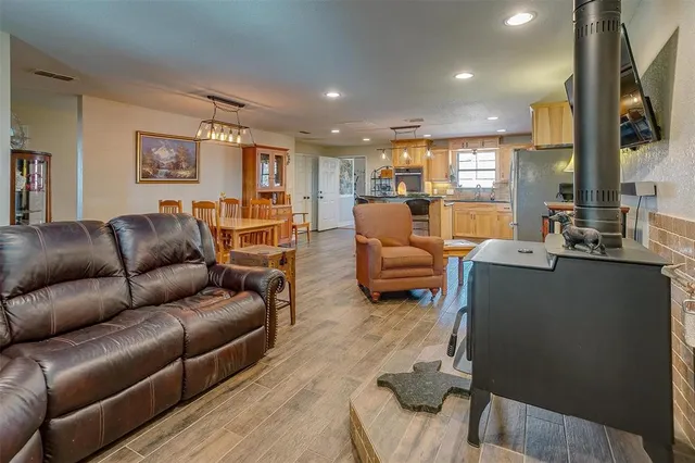 a kitchen with stainless steel appliances granite countertop a refrigerator a stove top oven a sink dishwasher and wooden cabinets with wooden floor