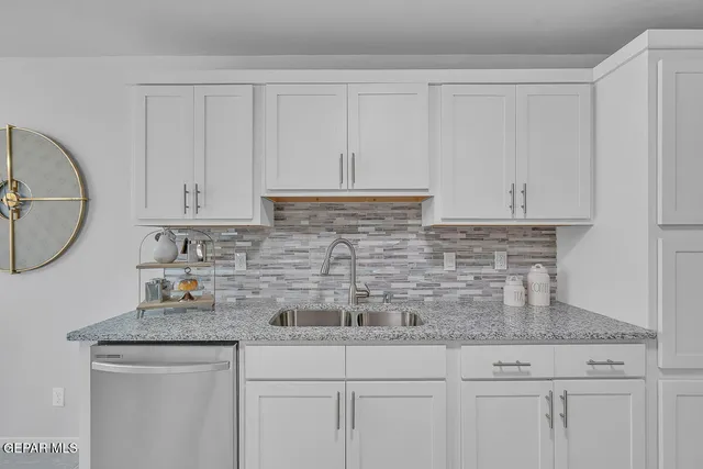 a kitchen with white cabinets and a sink