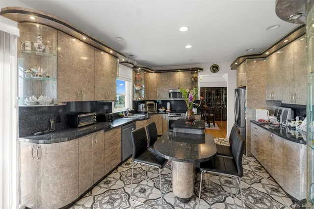 a kitchen with stainless steel appliances granite countertop a sink a stove and a refrigerator