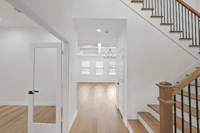 a view of a hallway with wooden floor and entryway