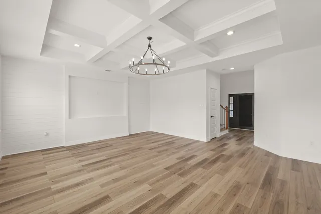 a view of empty room with wooden floor and ceiling fan