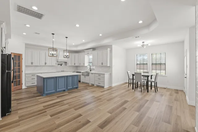 a large kitchen with stainless steel appliances lots of counter space and a dining table