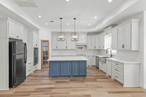 a large kitchen with kitchen island a sink stainless steel appliances and cabinets