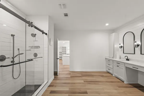 a bathroom with a shower sink and mirror
