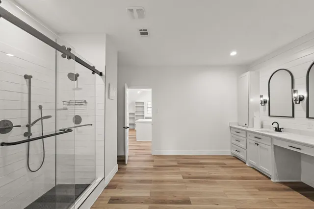 a bathroom with a shower sink and mirror