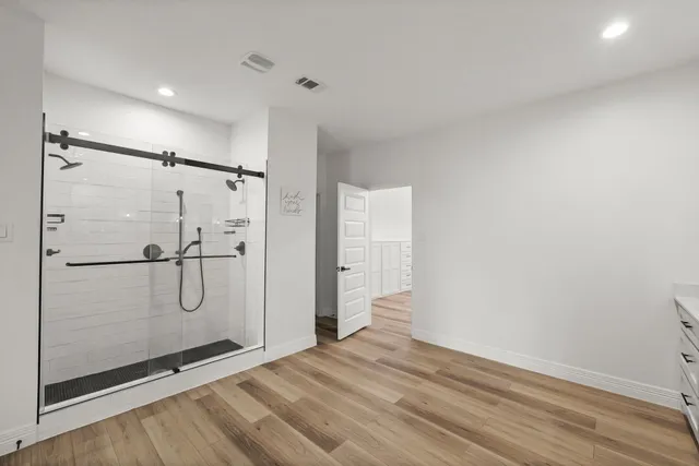 a bathroom with a shower and a glass door
