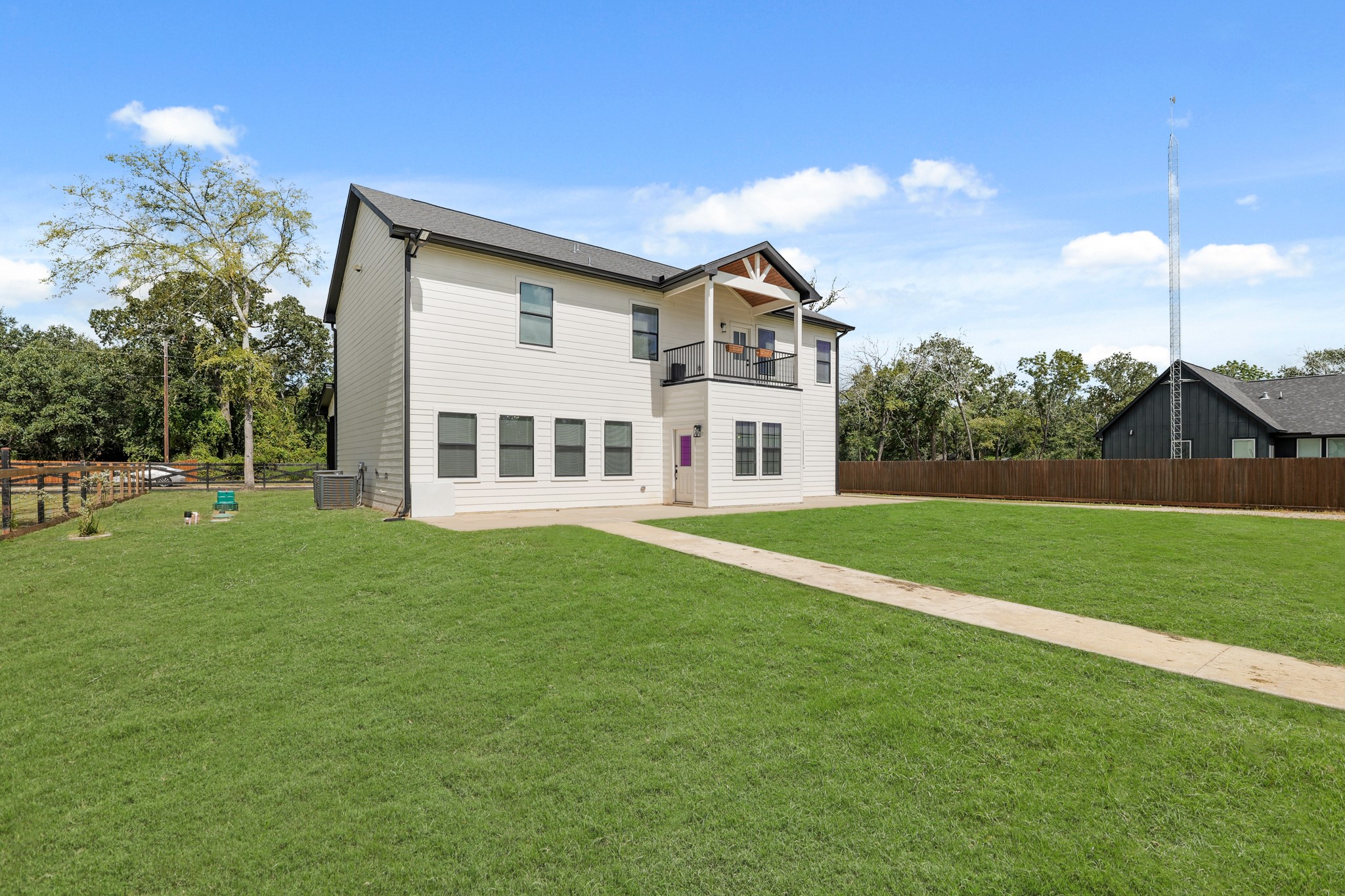 24585 Tipperary Street Hempstead, TX 77445 - Photo 8 of 50 Back view of home with oversized patio and view of primary room balcony.
