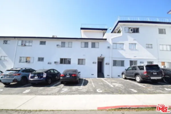 a front view of a house with cars parked