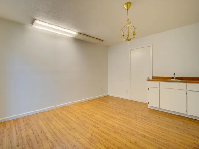a view of a room with wooden floor and white walls