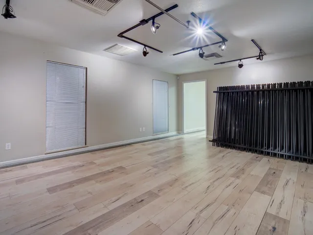a view of an empty room with wooden floor