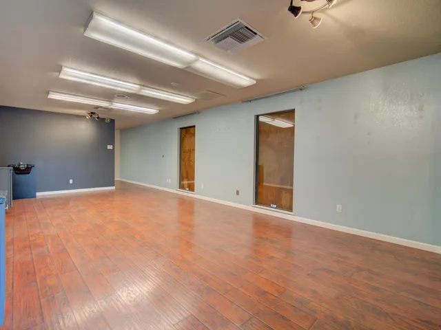 a view of an empty room with wooden floor