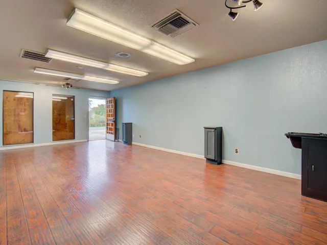 a view of an empty room with wooden floor