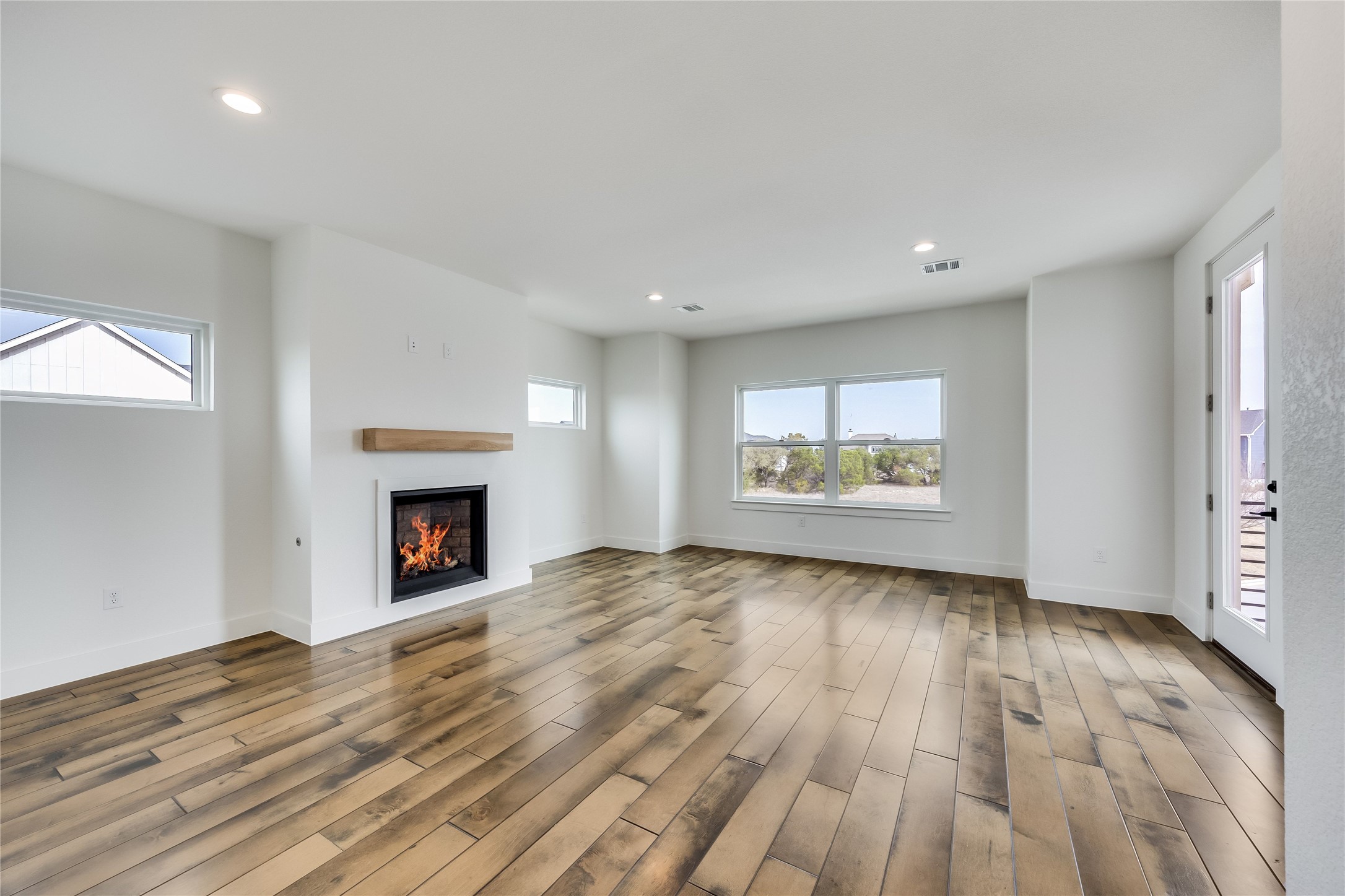 288 Smoke Tree Circle Dripping Springs, TX 78620 - Photo 24 of 40 an empty room with wooden floor and fireplace