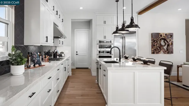 a kitchen with stainless steel appliances a sink stove and cabinets