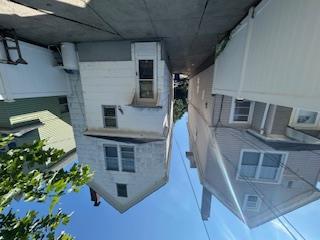 62-53 80th Road Queens, NY 11385 - Photo 2 of 11 Rear view of house with a chimney, a patio, and a fenced backyard
