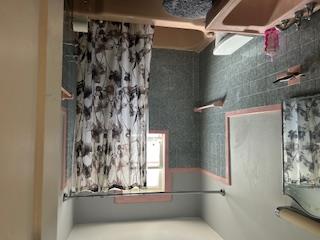 62-53 80th Road Queens, NY 11385 - Photo 10 of 11 Bathroom with tile walls, shower / bathtub combination with curtain, and vanity