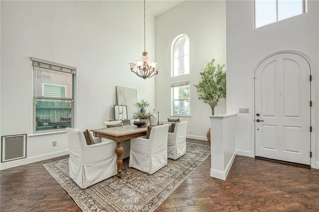 a view of a dining room with furniture a chandelier and wooden floor