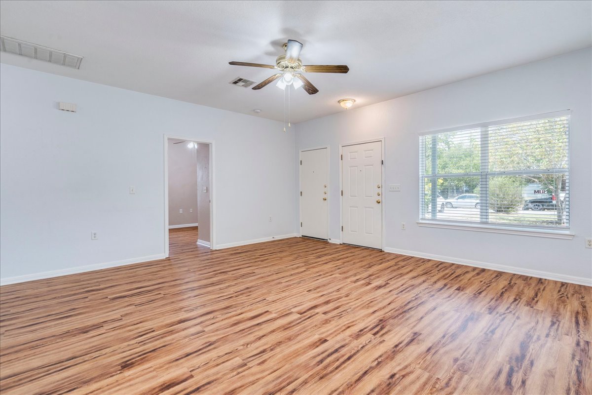 6801 Porter Street Austin, TX 78741 - Photo 6 of 30 A spacious living room features resilient vinyl plank flooring and an inviting window offering green views.