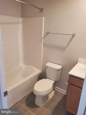 a white toilet sitting next to a bath tub