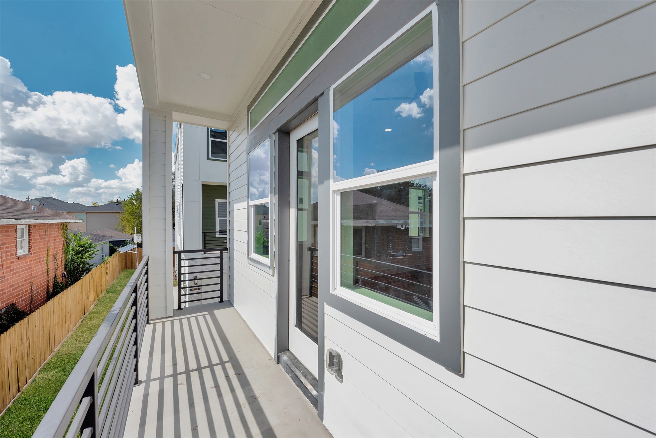 1805 Emir Street, Unit H Houston, TX 77009 - Photo 23 of 43 a view of a balcony with floor to ceiling windows with wooden floor