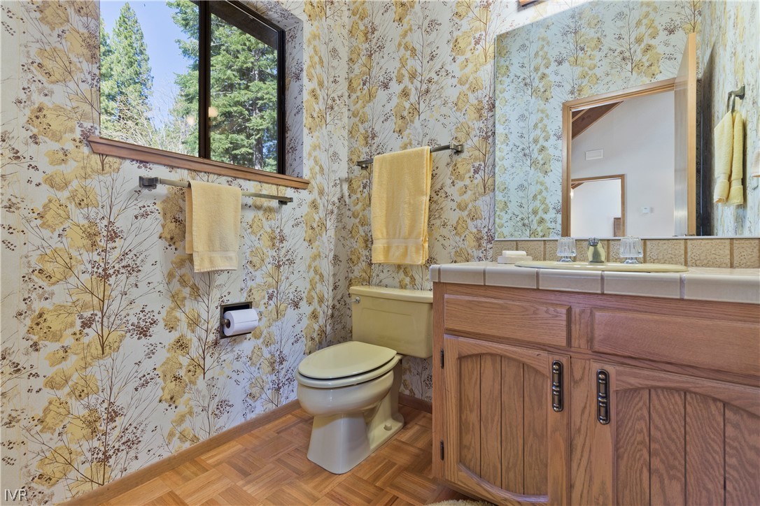 607 Crystal Peak Road Incline Village, NV 89451 - Photo 11 of 34 a bathroom with a granite countertop toilet a sink and a mirror